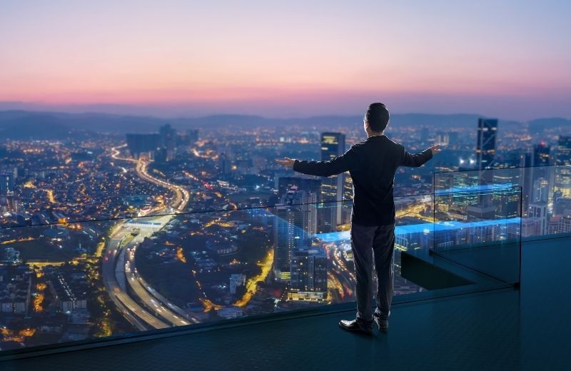 Man looking at city on edge on building